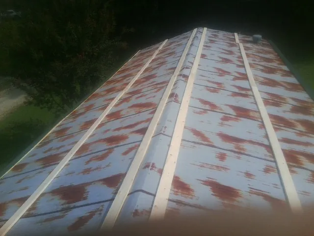 Rusted metal roof panels with new wood purlins before replacement — Storm Damage Roof Repair in Spring Church by Roofing Brothers