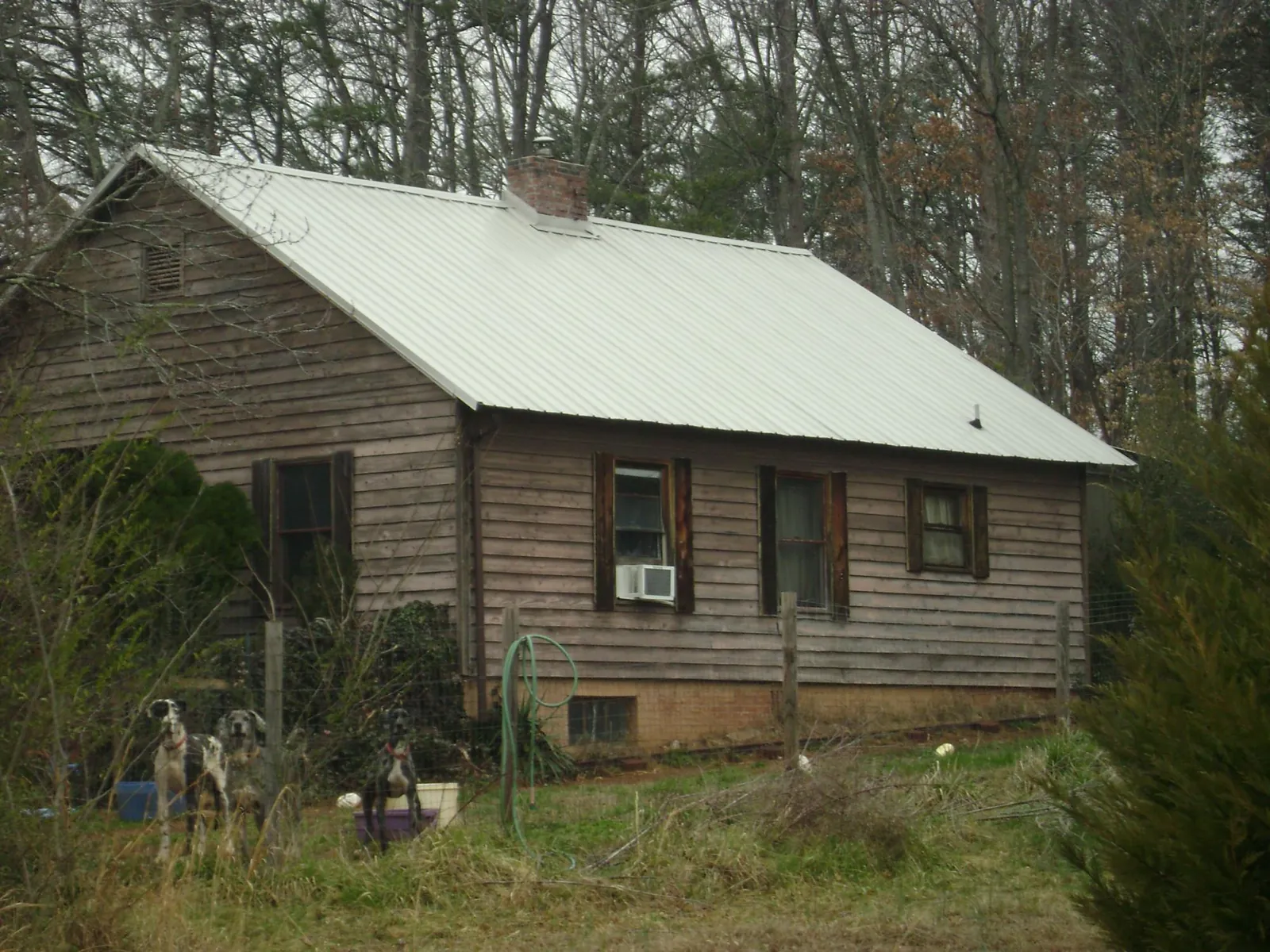 White metal roof on an old wood sided farmhouse, from a Metal Roof Installation job in Spring Church
